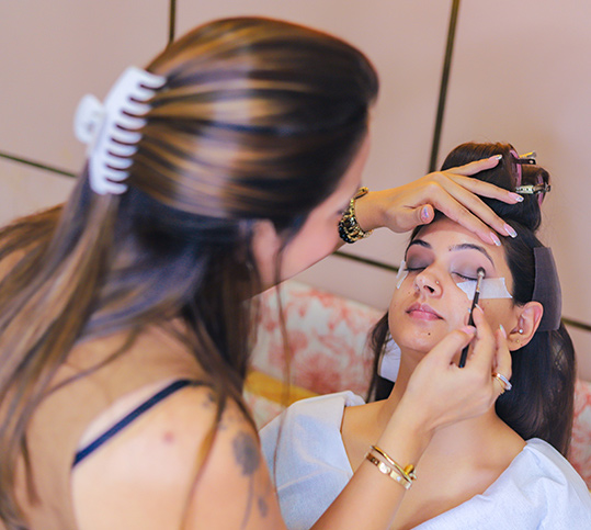 A bride getting ready with her Makeup Artist applying foundation or eye makeup